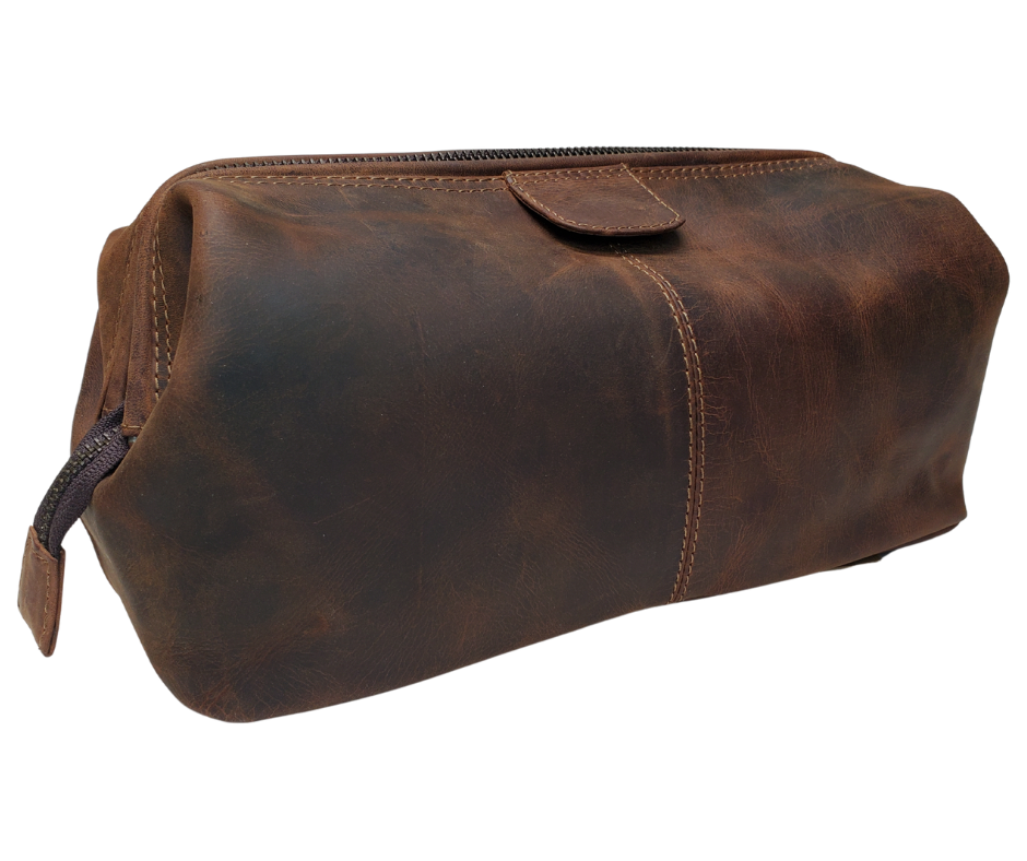 The Salesman, a Leather traveling Dopp bag, is available at our Smyrna, TN shop not far from Nashville. It has a framed opening that pops open with two pull tabs and zips closed. Lined with a slick fabric, there are 2 pockets on each side of a spacious main compartment.
Bag size: 9.75” x 4.5” x 4.75”
