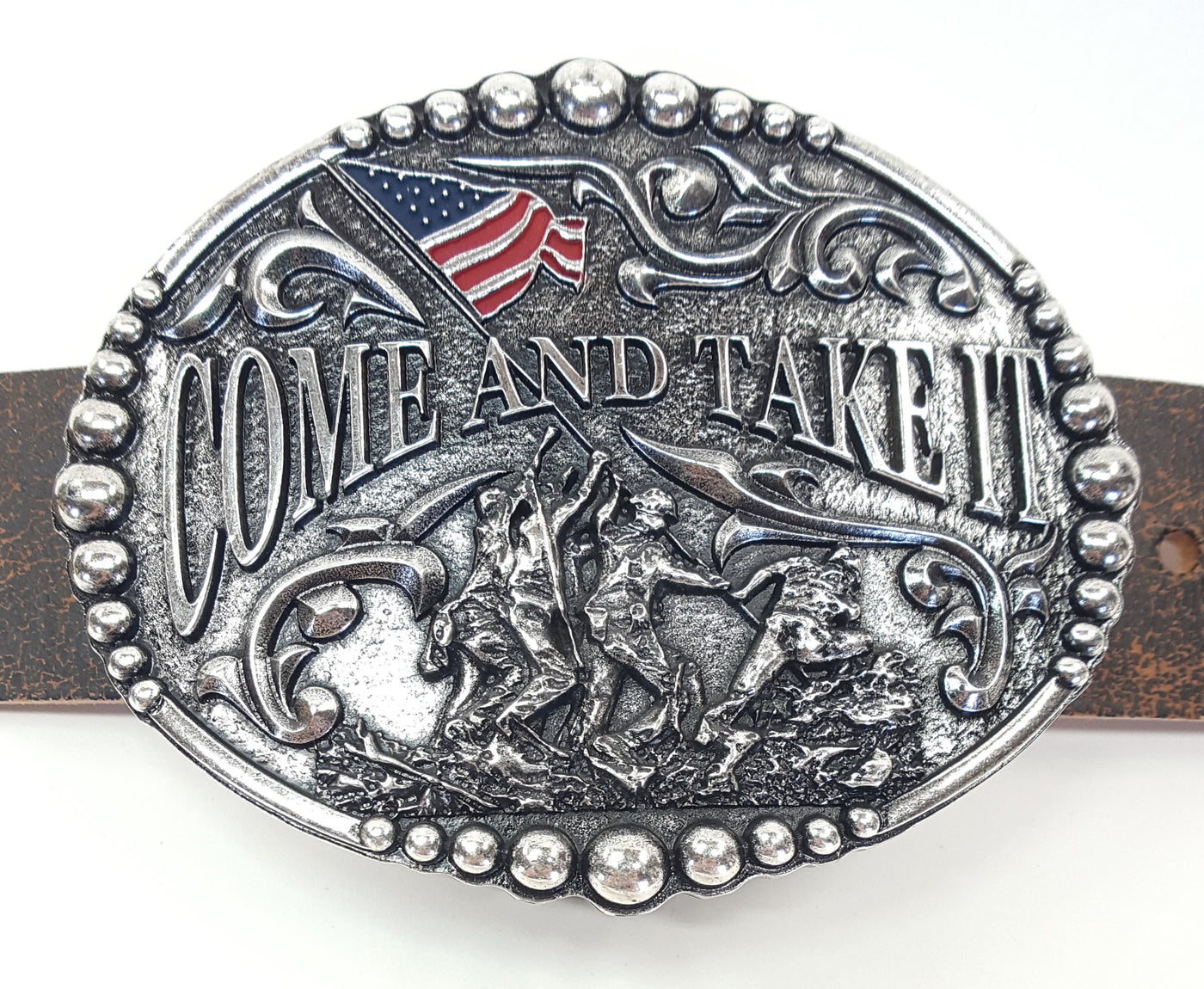 Come and Take It motif buckle by AndWest has Come and Take It wording and pictures soldiers raising and American Flag. Decorative scrolling and designs around edges. Dimensions are 3 2/4" tall by 4 1/4" wide Made in Mexico Available in our online shop as well as in the retail shop in Smyrna, TN, just outside Nashville. Pictured on belt.