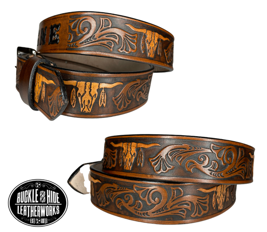 "The Longhorn"is a handmade real leather belt made from a single strip of cowhide shoulder leather that is 8-9 oz. or approx. 1/8" thick. It has smoothed edges and the Western / Longhorn scroll pattern is embossed on the surface. The antique nickel plated solid brass buckle is snapped in place.  This belt is made just outside Nashville in Smyrna, TN.