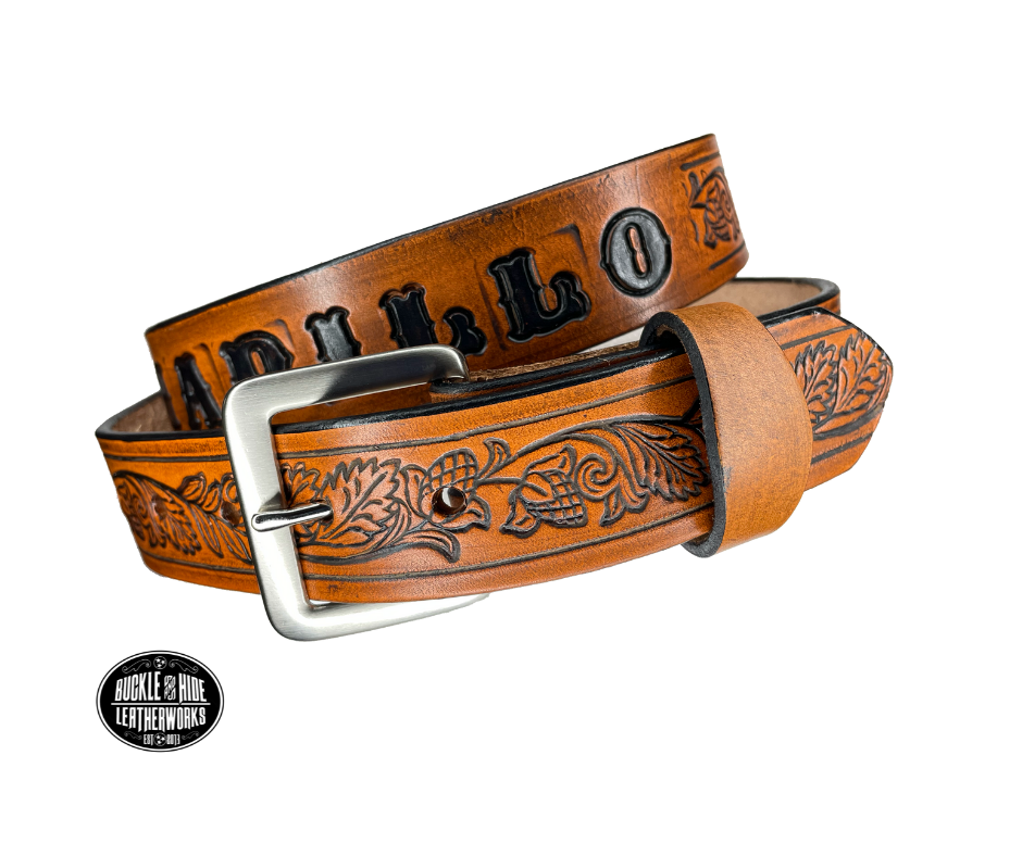 This solid strip of Veg Tan cowhide, is hand stained in 3 brown options, with smooth, finished edges. Embossed with Western Vine down length of belt, or have name added to scene up to 8 letters. Belt thickness is approx. 1/8", and 1 1/2" wide. Sizes available are 34" to 44" from buckle end to hole most worn. Attached with 2 snaps is a Brushed Nickel plated solid brass buckle. 