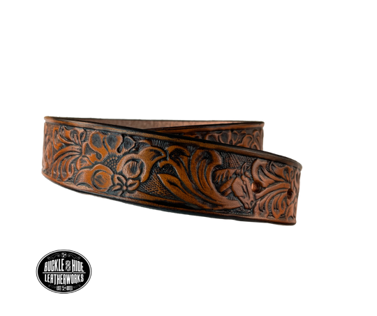 Introduce your little one to the iconic style of the west with the "Lil' Mustang" Leather KIDS/CHILDRENS Name Belt! Durable veg tan leather ensures that your cowboy or cowgirl can look good while feeling comfortable, and a unique western floral design featuring horses adds a touch of fun. A 1 1/4" width with snaps makes swapping out buckles a snap! Proudly made in Smyrna TN, just outside Nashville.
