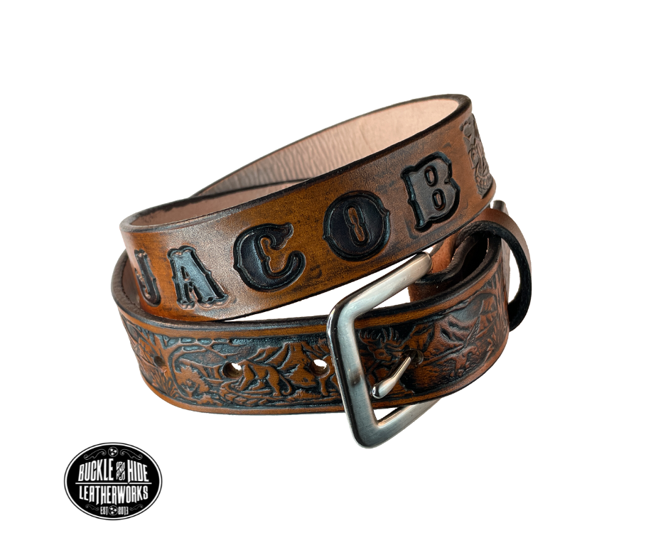 Perfect for the LIL Outdoors type the Wilderness scene embossed on veg tanned cowhide belt, about 1/8" thick, 1 1/4" width, burnished painted edges. The buckle easily snaps into place, allowing for easy changing when desired. Handcrafted with care in our Smyrna, TN shop, our Lil' Wilderness belt guarantees satisfaction. Follow our belt sizing instructions for a perfect fit
