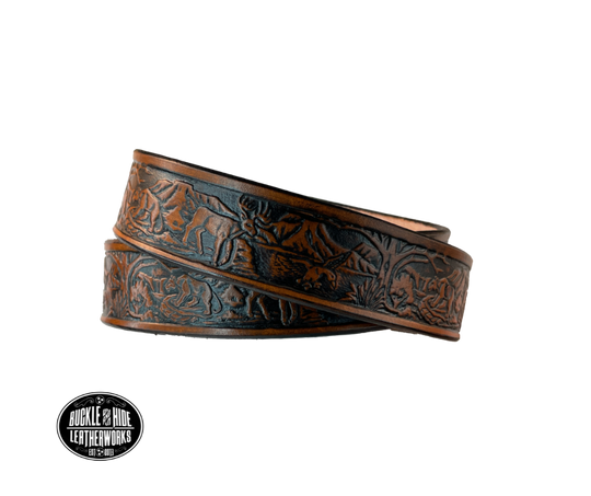 Perfect for the LIL Outdoors type the Wilderness scene embossed on veg tanned cowhide belt, about 1/8" thick, 1 1/4" width, burnished painted edges. The buckle easily snaps into place, allowing for easy changing when desired. Handcrafted with care in our Smyrna, TN shop, our Lil' Wilderness belt guarantees satisfaction. Follow our belt sizing instructions for a perfect fit