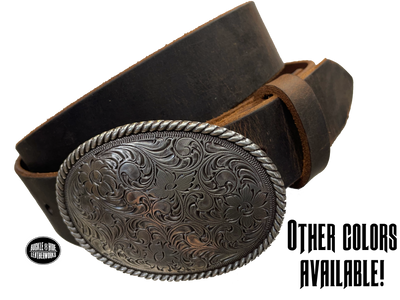 This oval shaped buckle by Nocona has a rope design around the border. It is chrome colored with scroll design etched appearance on surface.  Measures 2 3/4" tall by 3 3/4" wide and fits belts up to 1 1/2" wide. Buckle is made in Taiwan. Belt is a solid strip of leather and made in our shop in Smyrna, TN, just outside Nashville. It is 1 1/2" wide and available in sizes 34"-44" and colors distressed brown, black, and dark brown. ﻿It is available for purchase in our retail shop and online store. Main photo.
