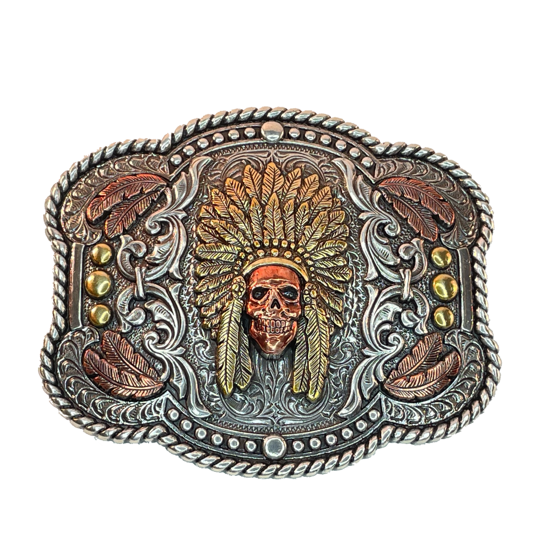 Nocona Indian Chief Skull belt buckle Rectangle shaped buckle with a stylish smooth edge. It features a centered Indian chief skull with headdress and feather motif surrounded by western scroll engraving. Copper and brass colors throughout. Measures 3-1/2" wide x 2-1/2" tall Fits belts up to 1 1/2" wide Available online or in our shop in Smyrna, TN just outside Nashville Add an authentic western look to your favorite belt.