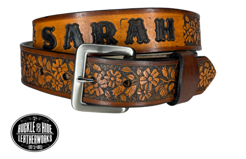 "The Beulah Land" is a handmade real leather belt made from a single strip of cowhide shoulder leather that is 8-10 oz. or approx. 1/8" thick. It has hand burnished (smoothed) edges and summer flowers embossed in 3 color options.  The antique nickel plated solid brass buckle is snapped in place with heavy snaps.  This belt is made just outside Nashville in Smyrna, TN.