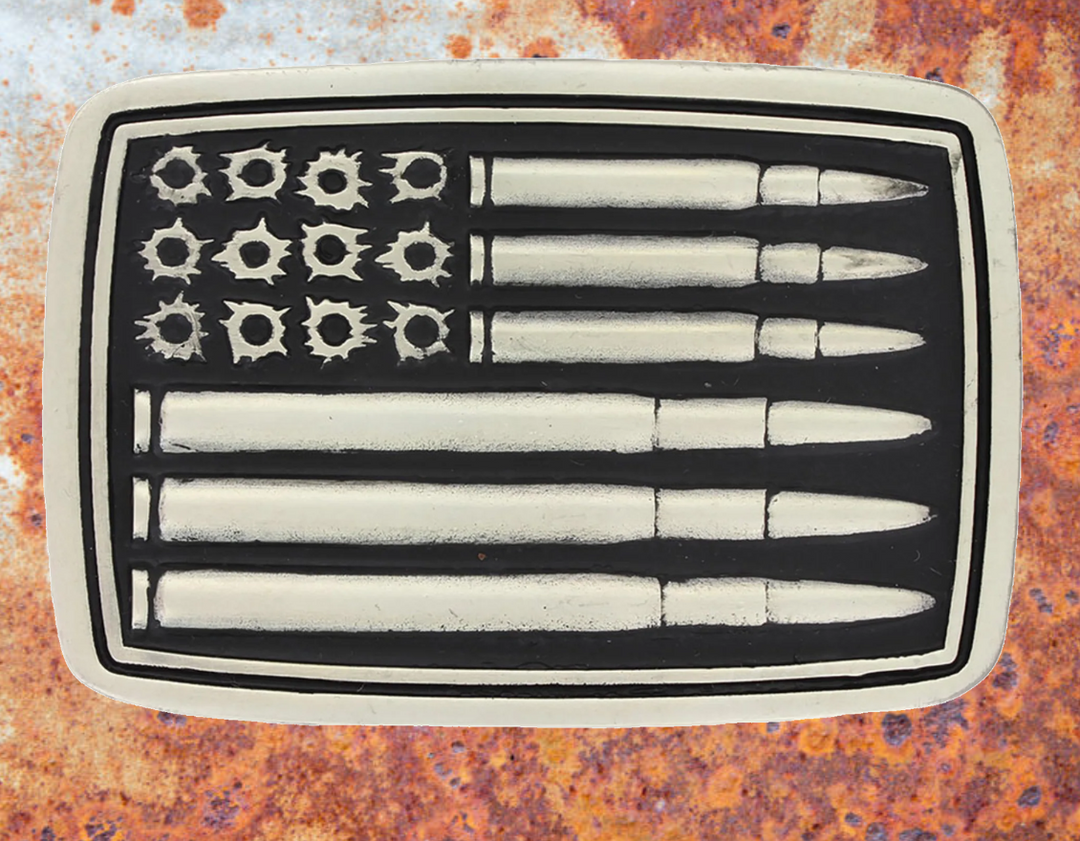 A deeply antiqued silver tone rectangular Attitude buckle with a overall flag design but instead of stars and stripes there are bullet holes and bullets. Standard 1.5 inch belt swivel. Available online and at our shop just outside Nashville in Smyrna, TN.