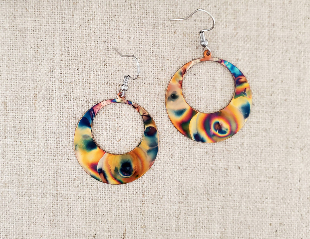 -Hand cut and finished copper blanks that are then flame painted with a torch -Sealed to keep the finish -Ear wires are stainless steel. -2" in length and 1 1/4" in width -Light weight -Each pair of earrings will look similar to the above pictured pair, but will vary slightly in color and pattern due to dealing with torch. -Earrings come on a tented card stock earring card for easy display- see photos for example. Stocked at our Smyrna, TN shop down I-24 from downtown.
