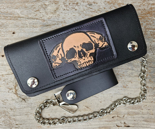 3 Skulls pattern all leather patch on a Classic Style Chain Wallet, great for the Modern minimalist. One credit card slot in the front with 2 main cash or whatever your STUFF is....5 year old receipts, concert stub from high school, the stuff you forgot was in there! Available in our Smyrna, TN shop a short drive from downtown Nashville. Like most wallets with over stuffing will limit the time of use. 
