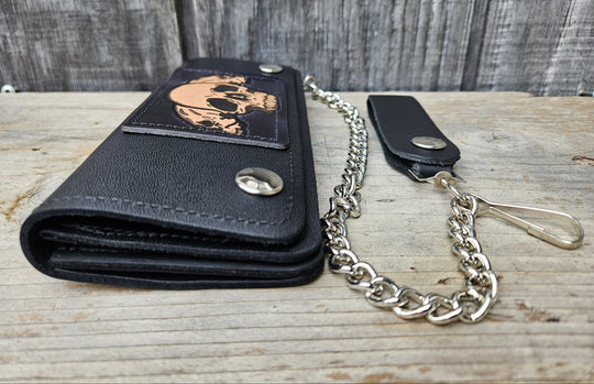 3 Skulls pattern all leather patch on a Classic Style Chain Wallet, great for the Modern minimalist. One credit card slot in the front with 2 main cash or whatever your STUFF is....5 year old receipts, concert stub from high school, the stuff you forgot was in there! Available in our Smyrna, TN shop a short drive from downtown Nashville. Like most wallets with over stuffing will limit the time of use. 