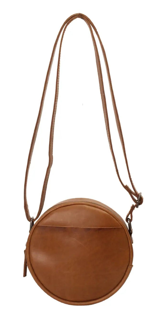 The Greta is a mini round crossbody bag crafted from vegetable-tanned Firenze Antiqua leather. This unlined crossbody features an adjustable strap for perfect fit. The smart key snap attached to the lace ensures effortless access to your essentials, adding a touch of convenience to this elegant accessory. Round everyone up and come see it for yourself at our Smyrna, TN store not far from Murfreesboro.