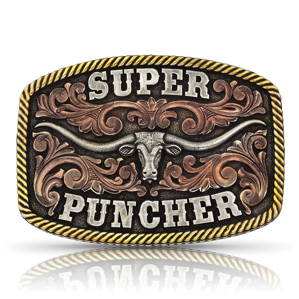 An officially licensed Dale Brisby tri-color buckle with a center antiqued silver Texas Longhorn  across the middle. High relief antiqued rose gold tone filigree below the longhorn with lightly antiqued silver tone bold western font spelling out "Super Puncher" and finished off with an antiqued gold tone rope edge. Fits 1 1/2" belts and is approx. 3" tall x 4"across. Available at our shop just outside Nashville in Smyrna, TN. Made by Montana Silversmith.