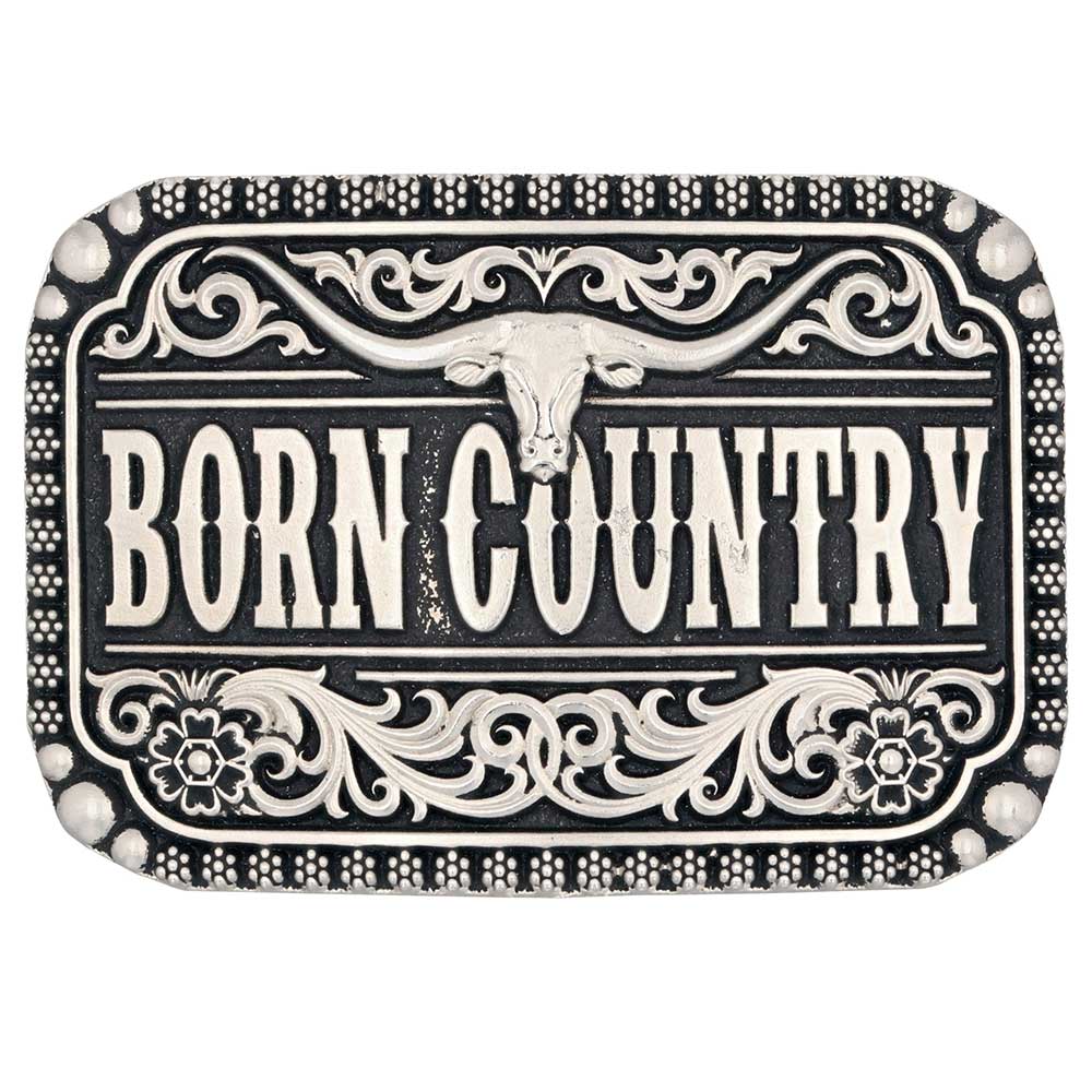 Wild, free, and born country. Show off your roots with this Silver-toned "Born Country" Buckle. With Born Country at the center of the buckle with a longhorn steer sitting above. Classic filigree highlights the top and bottom and additional silver-toned borders add texture. Flowers, and silver-toned beads border the outer edge. Fits 1 1/2" belts and is approx. 3" tall x 4" across. Available at our shop just outside Nashville in Smyrna, TN. Made by Montana Silversmith.