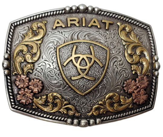 Ariat logo centered in the center and written across the top. Surface also has Classic Western Tri-Color scroll and flower designs and rope design with beads and rope around the border of the buckle. Color is antique silver with brass and bronze accents. Measures about 2 3/4" tall by 3 1/2" wide. Fits belts up to 1 3/4" wide. Available for purchase in our online store or the retail shop in Smyrna, TN, just outside Nashville. Imported


