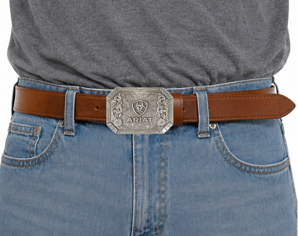 This rectangular buckle features rounded edges and a centered Ariat logo. The surface also boasts charming Western scroll and floral designs. The antique silver finish adds a touch of nostalgia. With a height of 2 1/2" and width of 3 1/2", it accommodates belts up to 2" wide. Purchase it on our online store or at our retail shop in Smyrna, TN, near Nashville. Imported