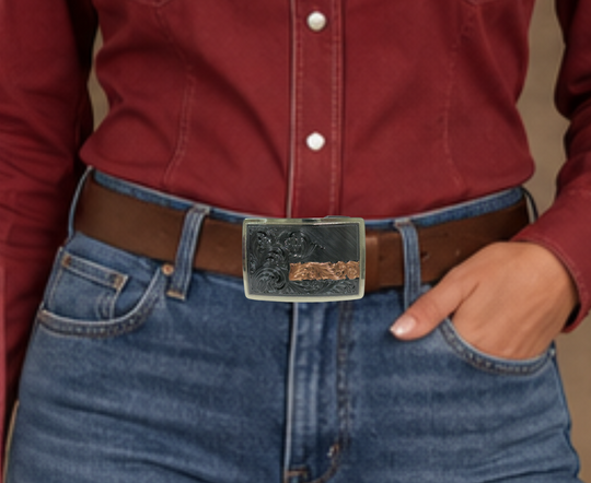 The Illusive is an attractive small, low-profile buckle engraved with a western scroll and diagonal lines. Crafted using a German Silver base, the border is a silver color, while the background is a gunmetal black, accented with a rectangular copper strip running through 2/3rds of the lower half of the buckle. Available in our Smyrna, TN shop, a short distance from Nashville.&amp;nbsp;

Dimensions: Width 3”, Height 2”

Standard 1.5” Swivel