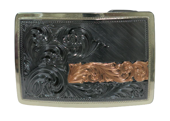 The Illusive is an attractive small, low-profile buckle engraved with a western scroll and diagonal lines. Crafted using a German Silver base, the border is a silver color, while the background is a gunmetal black, accented with a rectangular copper strip running through 2/3rds of the lower half of the buckle. Available in our Smyrna, TN shop, a short distance from Nashville.&amp;nbsp;

Dimensions: Width 3”, Height 2”

Standard 1.5” Swivel