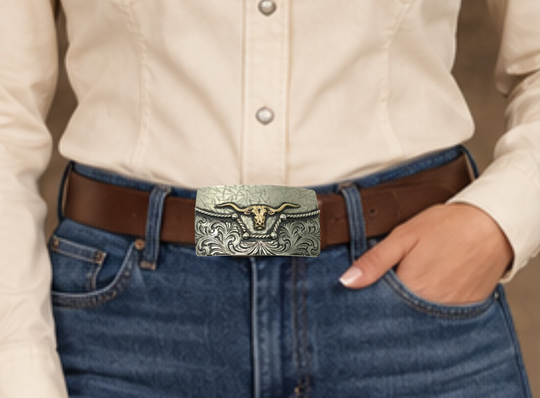 The River Horn impresses with an idea of a longhorn cattle neck deep in a river. In German Silver, the lower half of buckle is engraved in swirls forced from the center. It is separated from the lightly patterned top half with a rope dipping in the center to reveal the brass colored head of a Longhorn cattle. Available in our Smyrna, TN shop, a short distance from Nashville.