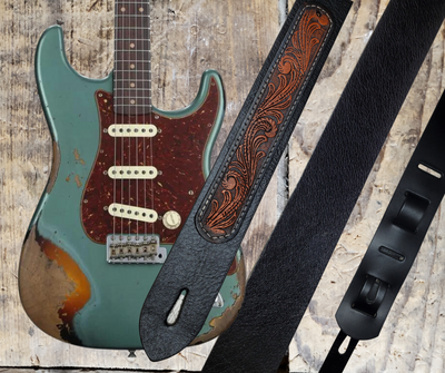 Electric Guitars, Great Songs and Lyrics have been staple for years in Country music!  "This 2" or 2 1/2" wide Guitar Strap is a nod to that classic influence. The main Body of the strap is approx. 1/8" thick Black Leather Strap.  CUSTOMIZE your Color options on a  Western Floral LEATHER PATCH. The classic adjustment style goes from approx. 42" to 56" at it's longest . Made just outside Nashville in our Smyrna, TN. shop. It will need a bit of time to "break in" but will get a great patina over time. 