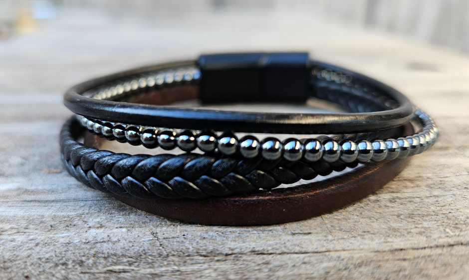Artisanal Turkish braided Leather Bracelets. Designed for Comfort and Tailored for a regular fit, these bracelets offer a comfortable wear experience for any wrist size. Whether worn solo or layered with other accessories these are suitable for both men and women. New to our shop in Smyrna, TN.

Fit's up to a 8" wrist.
Mix of Black and Brown leather with metallic beads
4 strands, round, flat, and beaded leather strips
Black Magnetic clasp