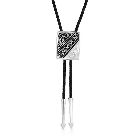 Discover the Four Winds of the Southwest Bolo Tie by Montana Silversmiths, available at our Smyrna, TN store near Nashville. This playful accessory showcases intricate filigree, bold Southwestern geometric designs, and detailed silver engravings. It comes with a 36-inch genuine leather cord and silver-tone tips, making it a fun and stylish match for any shirt in your wardrobe.