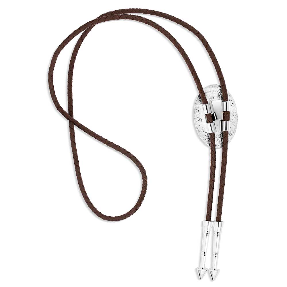 The Outlaw Turquoise Bolo Tie, from Montana Silversmiths is available in our Smyrna, TN shop just outside of Nashville. Has a silver tone oval base that has bright cut engravings that frame the center turquoise stone. The brown braided leather cord is weighed with two silver arrow pointed tips to complete the bold design. Stone color and detail will vary.