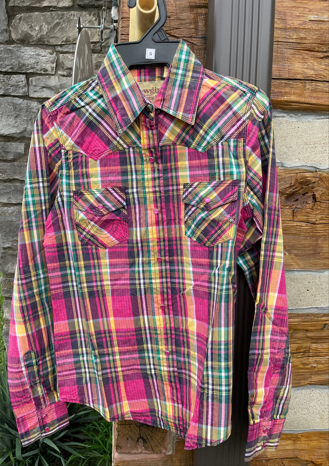 The Cowgirl Legend Ladies Spunky Plaid Shirt offered in long sleeve. A dominant hot pink is accented with yellows, whites, greens, and grays blended together in a traditional plaid pattern. Complete with two front flap pockets, and pearl snaps. These shirts are always in style,and especially if you want to keep Steve guessing what you&
