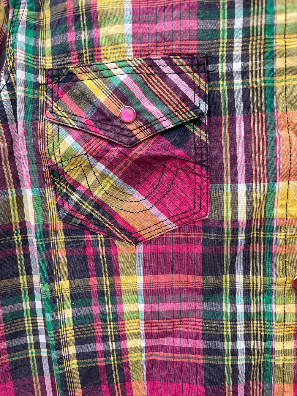The Cowgirl Legend Ladies Spunky Plaid Shirt offered in long sleeve. A dominant hot pink is accented with yellows, whites, greens, and grays blended together in a traditional plaid pattern. Complete with two front flap pockets, and pearl snaps. These shirts are always in style,and especially if you want to keep Steve guessing what you're going to do next! Available in our Smyrna, TN shop not far from the Miller Coliseum in Murfreesboro. Imported

Details: Pearl Snaps, 2 Pockets, Yokes, 100% Cotton