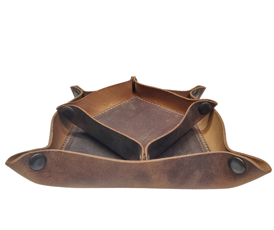 Our Rustic Distressed Leather Valet Tray, crafted in Smyrna, TN, easily folds flat by unsnapping its four Antique Brass snaps—perfect for travel. Its handy 4" x 4" size keeps your everyday essentials like keys and wallet organized. It pairs effortlessly with any style. Colors my vary.

Med. Approx. 8"x 8" (snapped)
Small Approx. 4.5"x 4.5" (snapped)