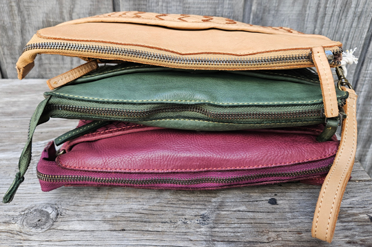 The Eve is made from soft tumbled leather and has a Woven front. The back side has a zippered pocket that will hold most smaller phone sized items. The main open inside pocket has one zippered pocket, 2 open top pockets 4 card size slots and one more smaller pocket next to to the cards. May be carried with the Wrist loop or as a Crossbody style with the included strap. The liner is a cotton fabric. Available now at our store in Smyrna, TN!

Measurements: 10" x 1" x 6"