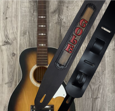 Acoustic Guitars and Great Songs and Lyrics have been staple for years in Country music!  "This 2" or 2 1/2" wide Guitar Strap is a nod to that classic influence. The main Body of the strap is approx. 1/8" thick Black Leather Strap with a CUSTOMIZABLE LEATHER NAME PATCH. The classic adjustment style goes from approx. 42" to 56" at it's longest . Made just outside Nashville in our Smyrna, TN. shop. It will need a bit of time to "break in" but will get a great patina over time.   