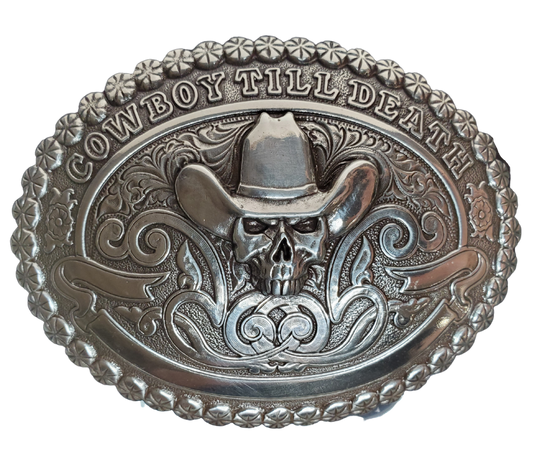 Treat your Cowboy Ways to something special. Our "Cowboy till Death" buckle has the classic vibes - scrolls, beaded edge, and a skull wearing a hat! Show your loyalty to the West! Measuring 2 1/2" tall x 3 1/2" wide, get it online or at our shop in Smyrna, TN, outside Nashville. Imported.