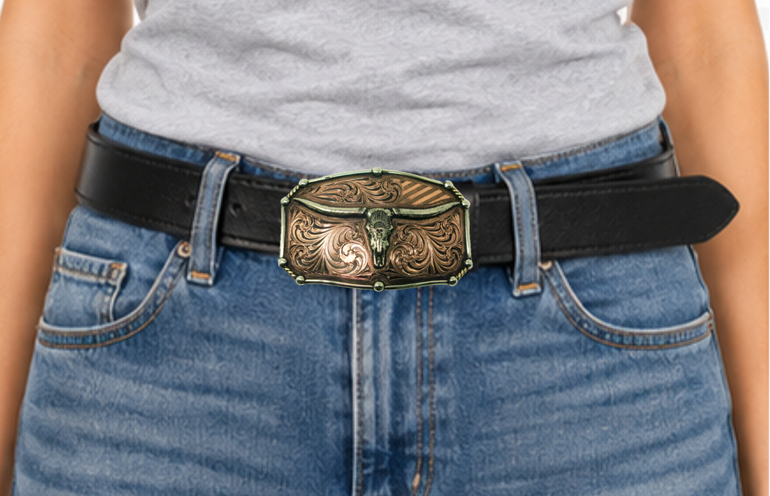 The Chief Longhorn buckle  These buckles are made from German Silver (nickel and brass alloy) or iron metal base. Some buckles have motifs made of copper, iron or brass and some are adorned with synthetic stones. These are all handcrafted. Each piece is punched, cut, soldered, engraved, polished and painted by our talented metal workers.  Available in our Smyrna TN shop. Width 4.5” Height 3”
Fits Standard 1.5” belts