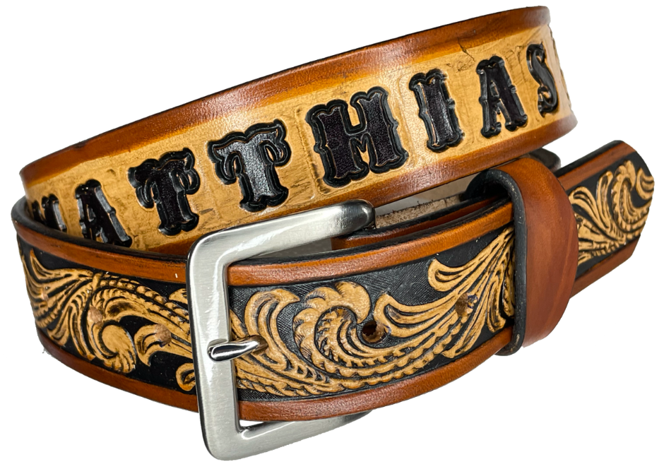 This DELUXE Rustler Name Leather Belt features a classic western Scroll pattern embossed on a 9-10 oz. vegetable-tanned cowhide. You may customize the buckle with the added snaps. It is named Deluxe because of the additional color added to the background of the pattern. This product is crafted with care in our Smyrna, TN shop, just outside Nashville, TN.