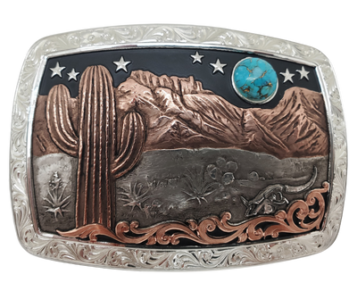 A Southwest buckle that's not so big! This 99% Silver rectangular belt buckle has Scroll work around the outer edge with a 18 karat Rose Gold Cactus, Mountains and a Turquoise Moon over the Desert scene. It's size is approx. 3" across x 2 1/2" tall and fits 3 3/4", fits up to 1 1/2" belts. Available at our Smyrna, TN just a short drive from downtown Nashville. Made by Montana Silversmith.