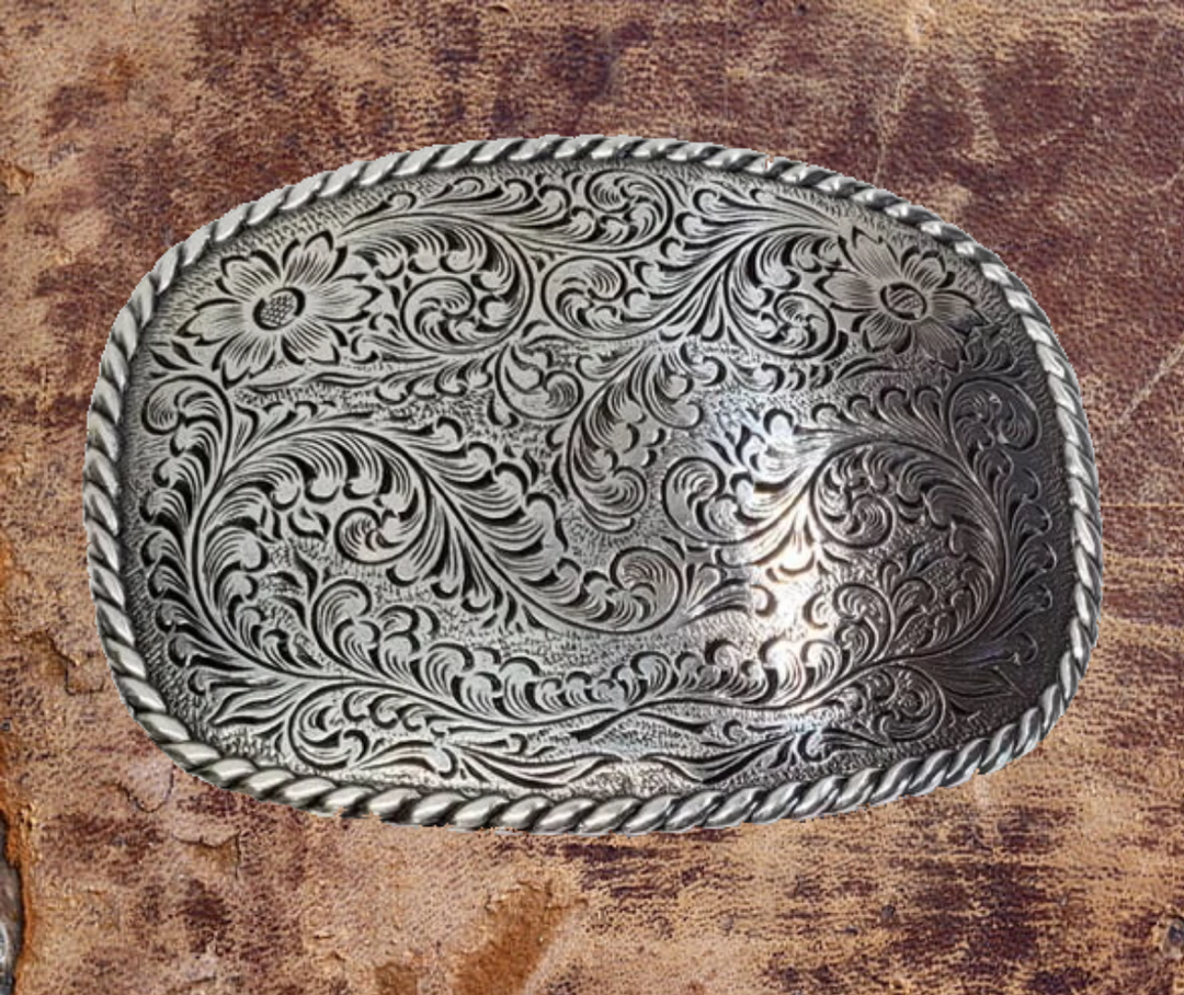 Nocona Rectangular Western Buckle back-This rectangular shaped buckle by Nocona has rounded edges with rope design around the border. It is chrome colored with scroll design etched appearance on surface.  Measures 2 3/4" tall by 3 3/4" wide and fits belts up to 1 1/2" wide.  It is available for purchase in our retail shop in Smyrna, TN, just outside Nashville and also on the online store. Made in Taiwan. 