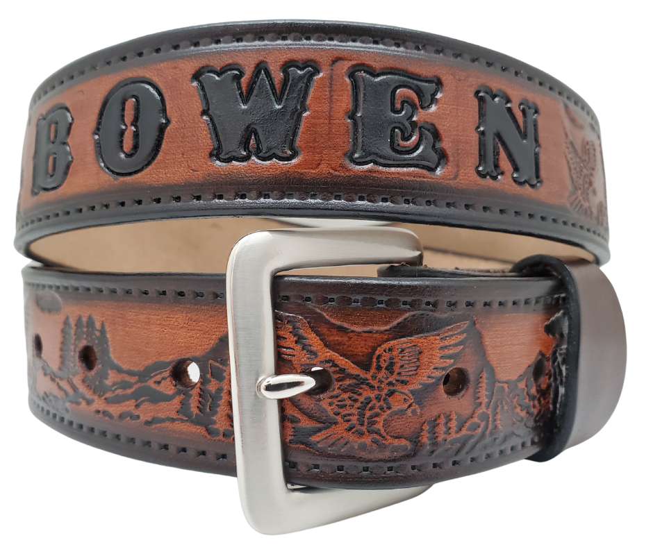 Get ready for an unforgettable climb to the top with The "Eagle Mountain" Name Belt! This one-of-a-kind belt features a 1 1/2" width and is hand-stained with a strip of vegetable tanned leather. The bold design includes a embossed Stitch border and Eagle center pattern, while the solid brass buckle in antique nickel finish adds a touch of ruggedness. Handcrafted at our shop in Smyrna, Tennessee, just outside Nashville.