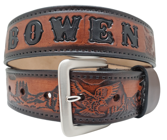 Get ready for an unforgettable climb to the top with The "Eagle Mountain" Name Belt! This one-of-a-kind belt features a 1 1/2" width and is hand-stained with a strip of vegetable tanned leather. The bold design includes a embossed Stitch border and Eagle center pattern, while the solid brass buckle in antique nickel finish adds a touch of ruggedness. Handcrafted at our shop in Smyrna, Tennessee, just outside Nashville.