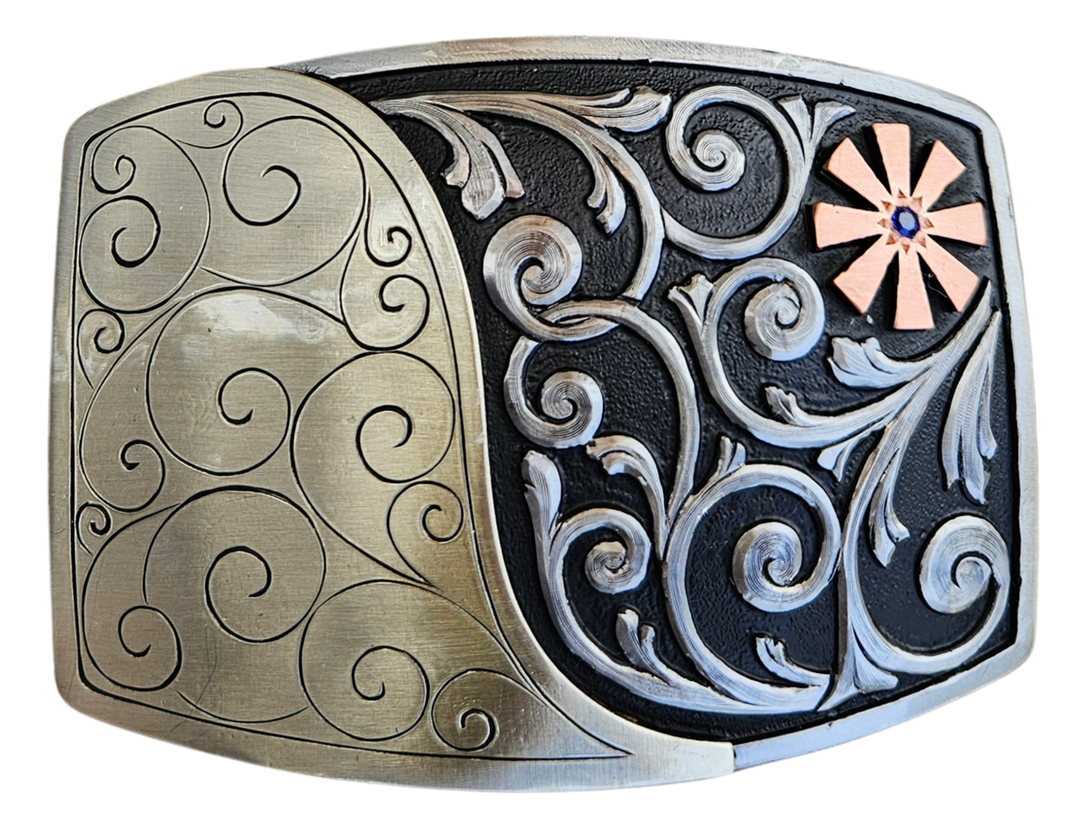 The Endless Breeze Belt Buckle has a more contemporary design accented with multi Scrolls divided into right and left colors and a Copper colored cog wheel on the top right. Made from German Silver and engraved and layered metals in a tri-color design. Available in our Smyrna, TN shop, a short distance from Nashville.

Dimensions: Width 4”, Height 2.7”
Standard 1.5” Swivel