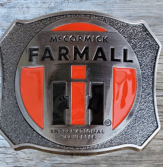 Farmall International Harvester Belt Buckle, Shield shaped with classic logo in Red, Black on antique Silver background. Size approx. 3 3/4" wide x 2 3/4" height, Fits up to 1 1/2" wide belts. Available in our shop in Smyrna, TN just outside Nashville as well as from this online store.