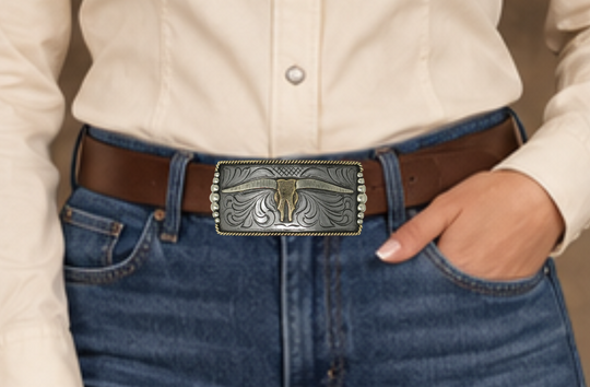 One of our more unique buckles, it has a rectangle shape with a Western scroll design, and a beaded rope edge framing a Longhorn steer. This buckle is made from German Silver (nickel and brass alloy) or iron metal base. Some buckles have motifs made of copper, iron or brass and some are adorned with synthetic stones. Buckle size is Width 5” Height 2” and is available in our Smyrna, TN shop.