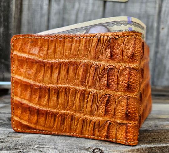 If you appreciate craftmanship this USA Made Genuine Hornback Crocodile Bifold will do the trick. Genuine Ostrich Lining is complete with matching Leather Lining, 1 Bill Pocket, 8 Card Slots, 2 Inner Side Pockets. Each hide is unique, each wallet is unique! Handmade in USA and sold in our Smyrna, TN shop not far from the gulch downtown Nashville.

Thin profile