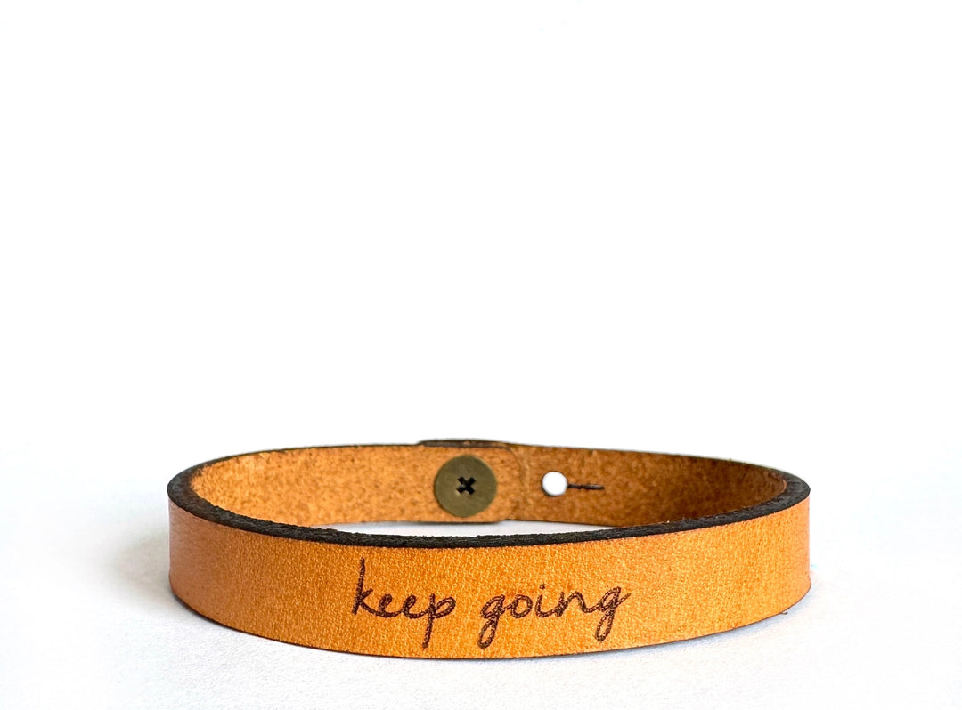 Inspiring Leather Bracelets Stocked at our Smyrna, TN shop. Keep Going is made from a quality full grain leather, laser engraved with encouragement for the wearer. Stud adjustable length: 7 and 7 1/2 x 3/8 in