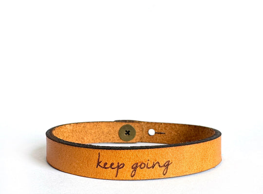 Inspiring Leather Bracelets Stocked at our Smyrna, TN shop. Keep Going is made from a quality full grain leather, laser engraved with encouragement for the wearer. Stud adjustable length: 7 and 7 1/2 x 3/8 in