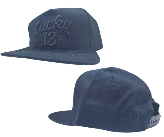 The Lucky 13 Shocker solid twill snapback trucker cap has the vintage-inspired "Lucky 13" graphic on front and a "Lightning Bolt 13" embroidered on the back left side. There is an adjustable snap back to assist in helping this hat fit almost any size head. Come and and get'em at our Smyrna, TN shop a short ride outside Nashville.

COLOR: BLACK