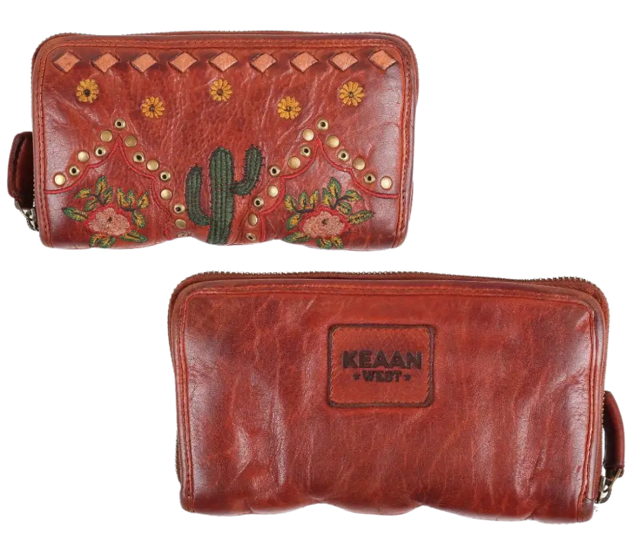 If a Desert was a wallet it would a Saguaro cactus design, embroidered sunflowers, desert roses, and distressed metallic embellishments for that Western flair, all crafted from the signature butter-soft calf Nappa leather. And don't miss the touch of distressed white lace - because who says a wallet can't have a little fun? Ride over and snag yours at our Smyrna, TN shop, not far from the wild west of downtown Nashville.