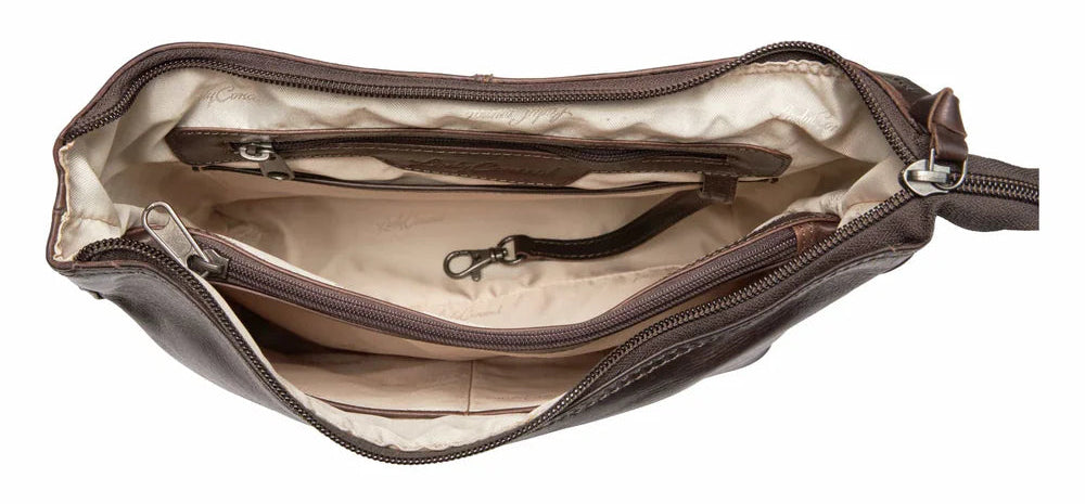 The Blake Scooped Leather Crossbody is crafted from premium full-grain leather, each piece showcasing its own natural variations in grain and shading. Intricate leather crisscross stitching adorns the front and sides, complemented by decorative long tassels for added charm. A large open pocket for your cell phone, and a leather key strap. A zippered pocket on the back adds more room for your essentials. Part of our Carry Conceal Handbags in our Smyrna, TN shop.