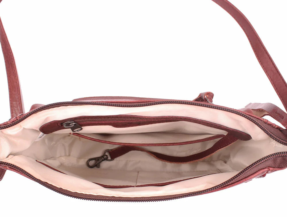 The Callie Leather Crossbody is crafted with quality full-grain leather, featuring stylish lacing on the front pocket and ends. The interior features a zippered pocket, 2 open slip pockets, another large open pocket, and a key strap for fast access to your keys. An additional zippered pocket on the back adds more room for your cell phone or other essentials. The ideal size for the lady on the go. Part of our Cary Conceal Handbags at our Smyrna, TN shop.