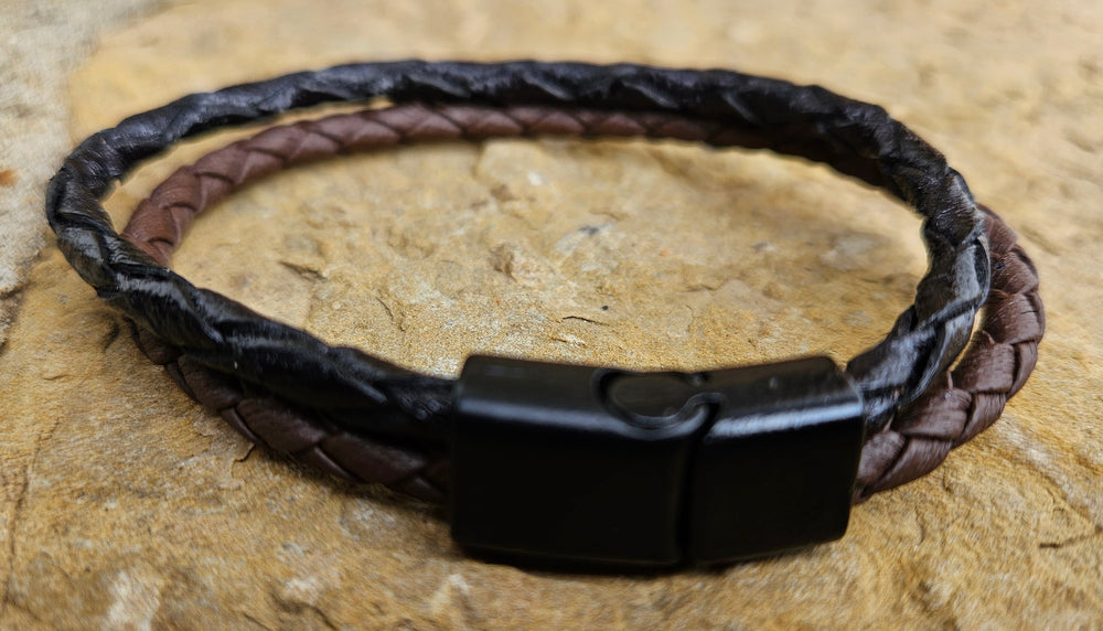 Plait is the word for 5 or more strips for a braid. The Cord of 2 is Leather meticulously handcrafted in Turkey. Designed for Comfort these bracelets offer a comfortable wear experience for any wrist size. Whether worn solo or layered with other accessories, they add a touch of rugged elegance to your attire. New to our Smyrna, TN shop come by and see them.

Fit's up to a 8" wrist.
5 strand braids, round in 2 cords of Black and Brown
Black Magnetic clasp