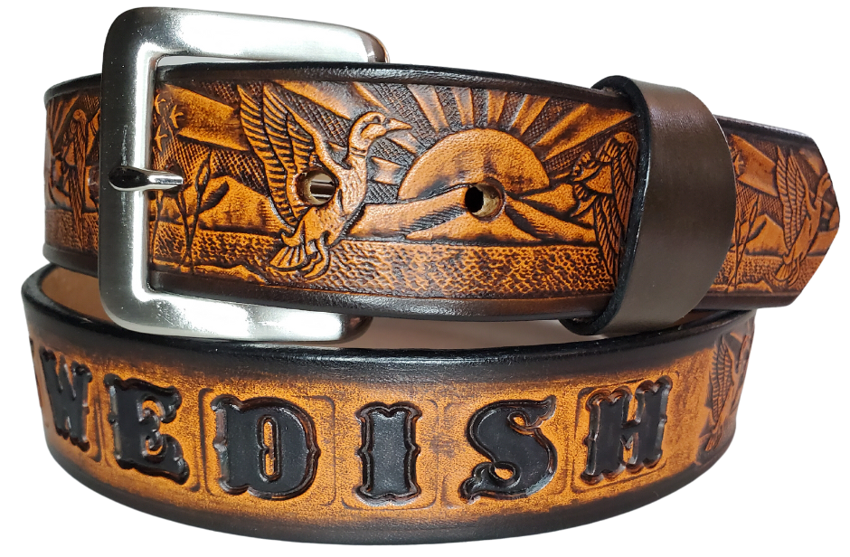 This solid strip of Veg Tan cowhide, is hand stained in 4 brown options, with smooth, finished edges. Embossed with a Mallard Duck scene down length of belt, or have name added to scene up to 8 letters. Belt thickness is approx. 1/8", and 1 1/2" wide. Sizes available are 34" to 44" from buckle end to hole most worn. Attached with 2 snaps is a Brushed Nickel plated solid brass buckle. 